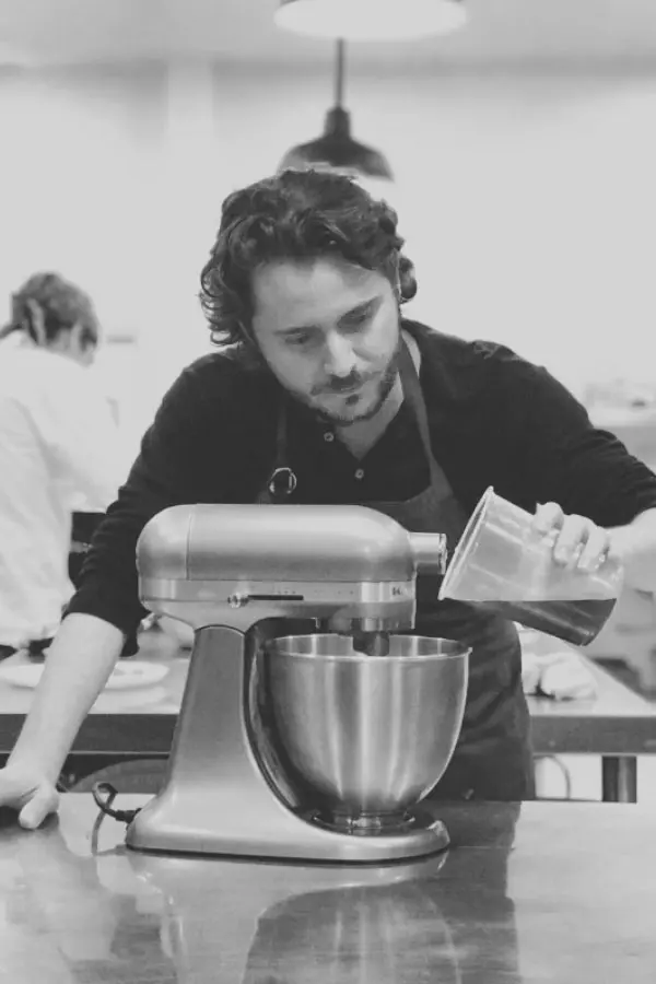 Muro de Stand con productos ilustrados necesarios para un proceso industrial de panadería. Alfrente dos personas caminan para un lado y otra en sentido contrario.